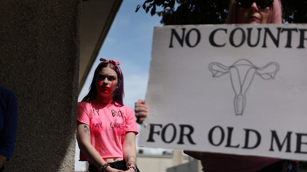 Dani Thompson leans against a pillar at the "Bans Off Our Bodies" march May 14 in Downtown Muncie. The march was hosted by the non-profit group Women's March. Rylan Capper, DN