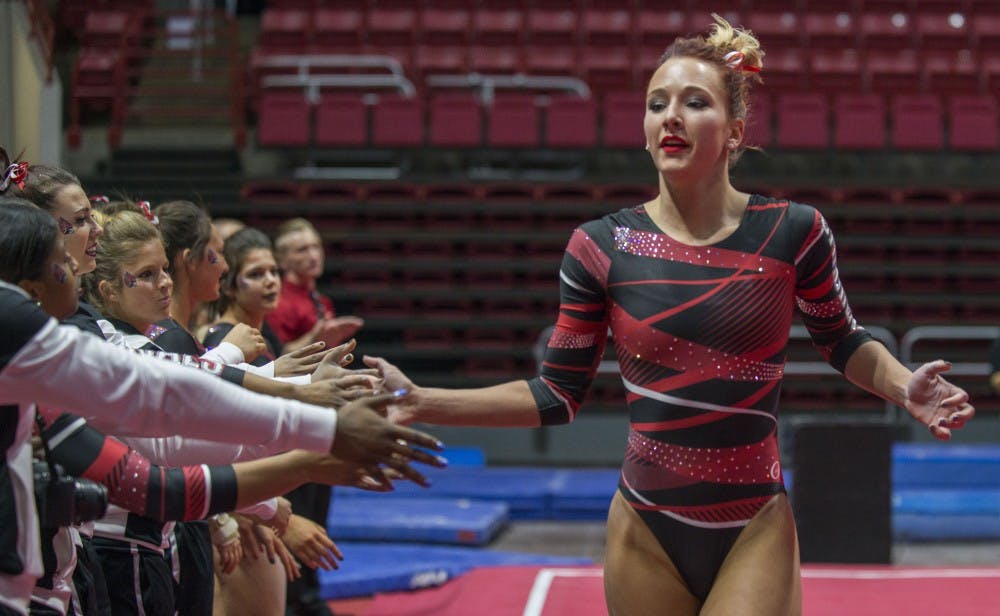 Senior Shelby Arms high-fives her teammates after completing her floor routine during the meet against Northern Illinois on Jan. 15 at Worthen Arena. Breanna Daugherty // DN