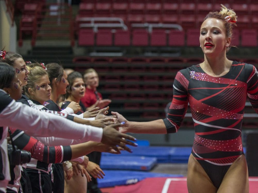 Senior Shelby Arms high-fives her teammates after completing her floor routine during the meet against Northern Illinois on Jan. 15 at Worthen Arena. Breanna Daugherty // DN