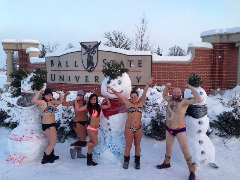 Brittany Roe, Candace King, Talia Traub, Chelsy Jones and Casey Clement pose in front of snowmen built by a group yesterday with Mark McCoy and Mike Davis. Traub