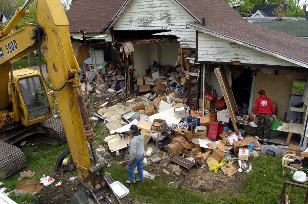 Workers from A&A Backhoe company scavenge for items from an abandoned building slated for demolition in Anderson, Ind. In 2005, the city started bulldozing abandoned houses that had become magnets for drug dealers, thieves and arsonists. MCT PHOTO