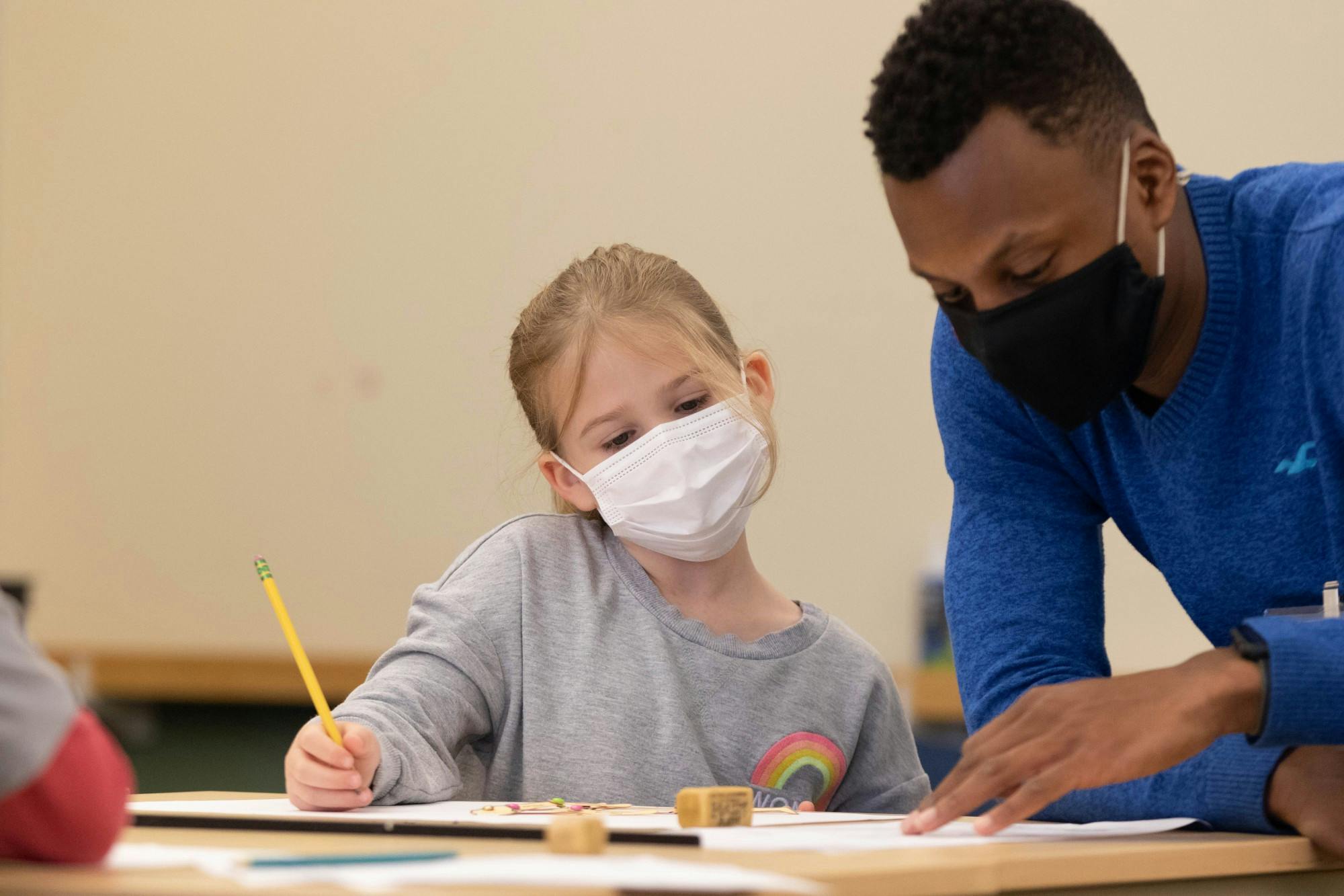 Sarah Waters works with Dominick Haskins, art education major, on her artwork during Saturday Children's Art Classes in the Art and Journalism Building Nov. 13. Eli Houser, DN 