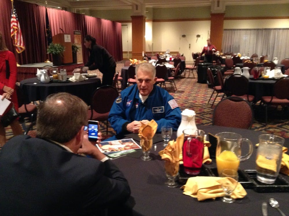 <p>David Wolf, center, sits after a breakfast at the Horizon Convention Center in Muncie. Wolf, a Hoosier astronaut, spoke on the importance of communication. DN PHOTO ALAN HOVORKA</p>