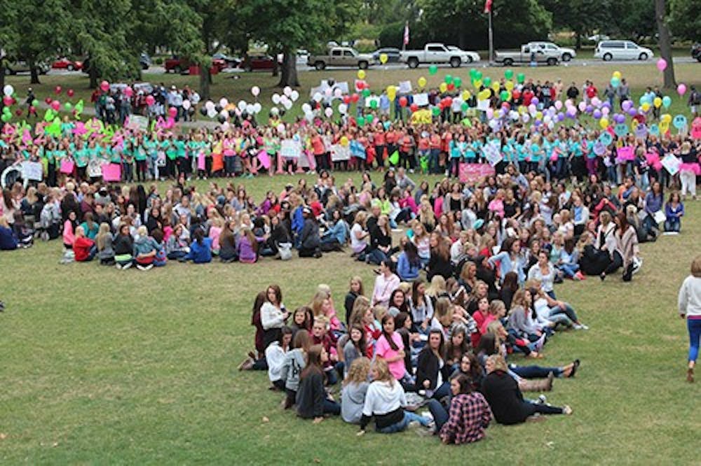 New sorority members sit on the Quad during Bid Day Monday evening. DN PHOTO TAYLOR IRBY