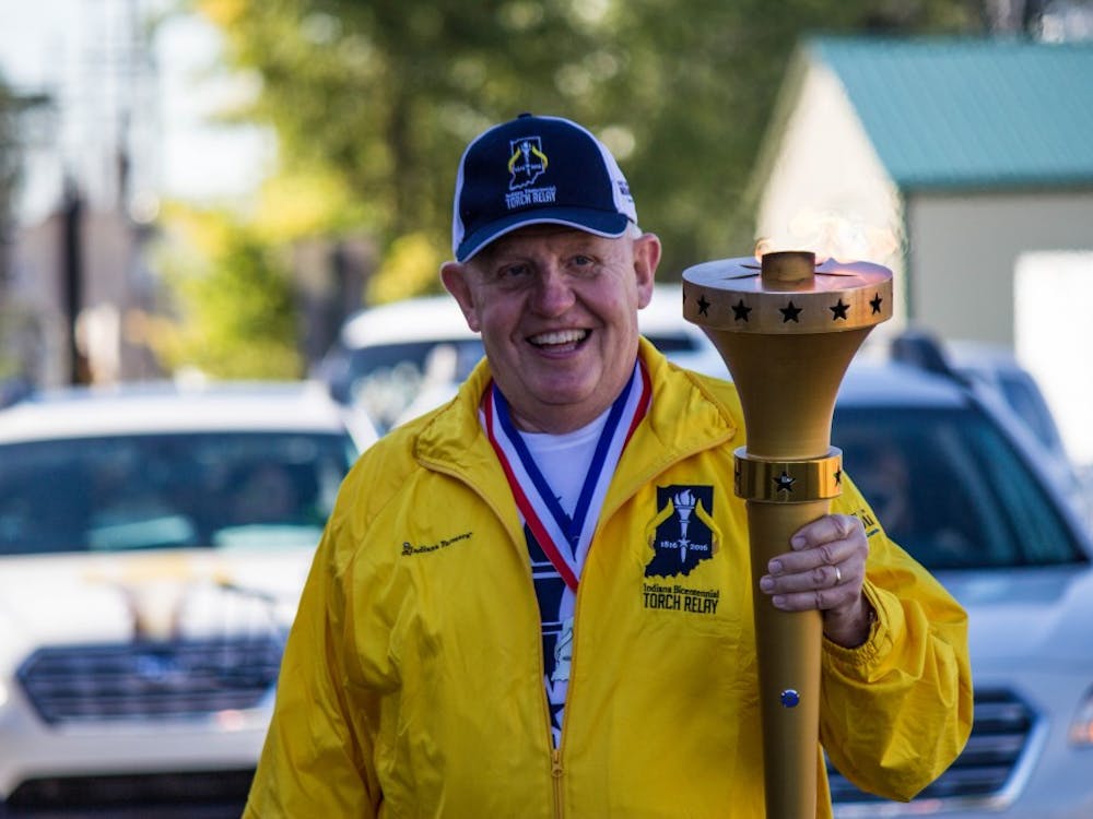 Alan Wilson, the 11th torchbearer, carries the torch through part of Delaware County on Sept. 27 for the Indiana Bicentennial Torch Relay. The relay started on Sept. 9 and will travel to all 92 counties in Indiana, and end on Oct. 15 in Indianapolis. Grace Ramey // DN