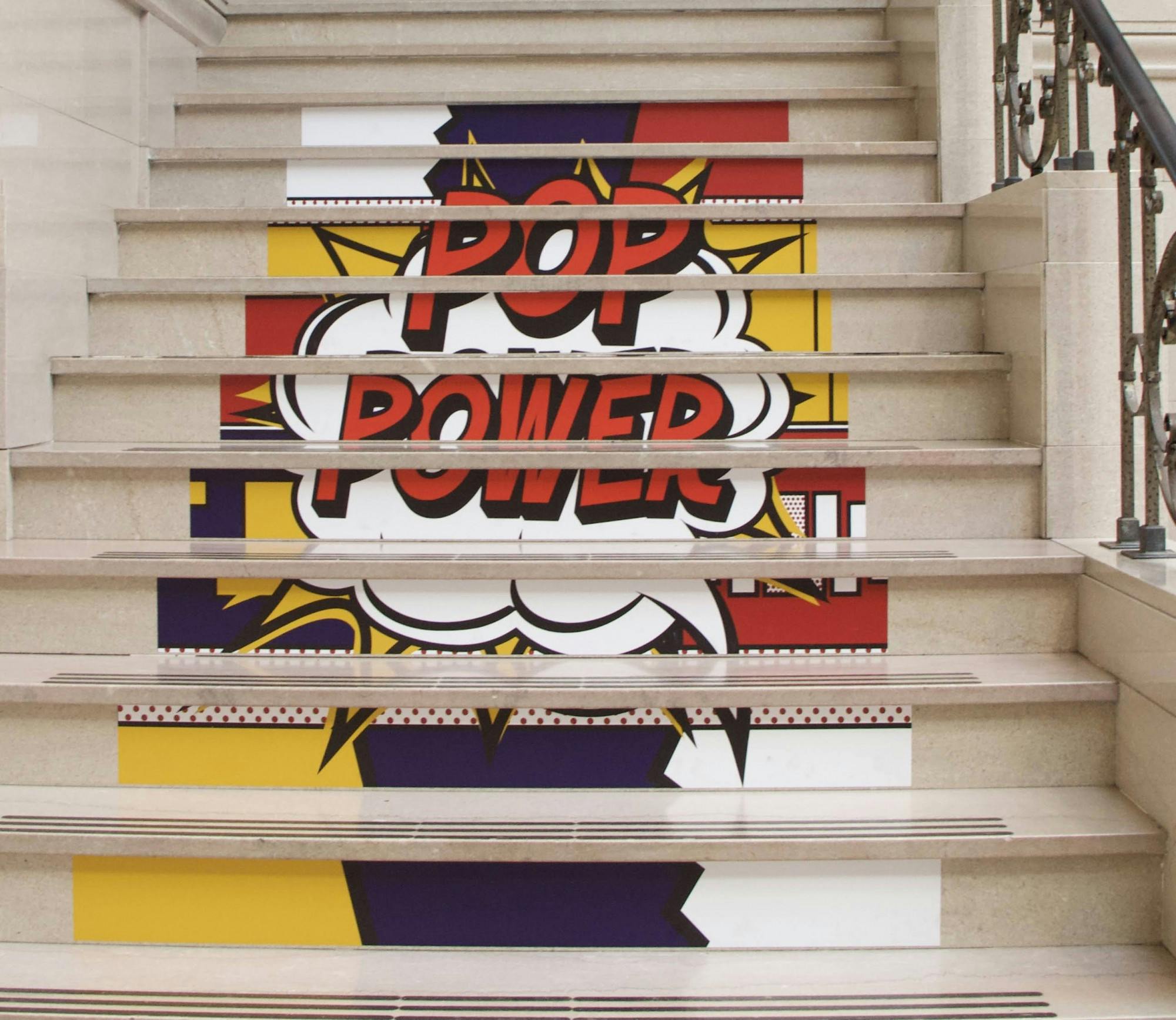 &quot;POP Power&quot; stickers sit on the stairs of the David Owsley Museum of Art (DOMA) May 11, 2021. DOMA Director Robert La France said staff wanted to experiment with stickers leading people to the second floor of the special exhibition instead of signs with arrows. Grace McCormick, DN