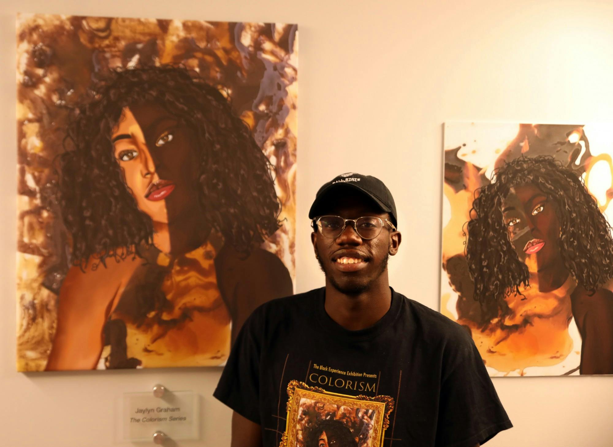 Jaylyn Graham poses for a photo next to his artwork &quot;The Colorism Series,&quot; Sept. 13 in the Multicultural Center. The piece was part of Graham&#x27;s senior exhibition &quot;The Black Experience.&quot; Rylan Capper, DN