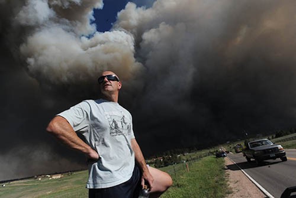 Dave Dunlap watches from the bed of his truck as the fire crosses Black Forest Road near his home in Colorado Springs, Colorado, Tuesday, June 11, 2013. The fire is effecting 40 and 60 houses in the area but there has been no loss of life reported. MCT PHOTO