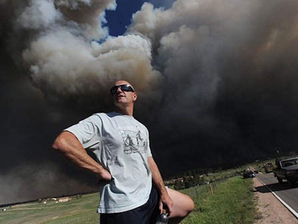 Dave Dunlap watches from the bed of his truck as the fire crosses Black Forest Road near his home in Colorado Springs, Colorado, Tuesday, June 11, 2013. The fire is effecting 40 and 60 houses in the area but there has been no loss of life reported. MCT PHOTO