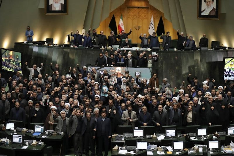 Iranian lawmakers chant slogans as some of them hold posters of Gen. Qassem Soleimani, who was killed in Iraq in a U.S. drone attack, in an open session of parliament, in Tehran, Iran, Tuesday, Jan. 7, 2020. Iran's parliament has passed an urgent bill declaring the U.S. military's command at the Pentagon in Washington and those acting on its behalf "terrorists," subject to Iranian sanctions. (AP Photo/Vahid Salemi)