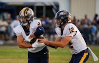 Senior quarterback Bronson Edwards hands off the ball to senior running back Bryce Stroble against Yorktown Sept. 13 at Yorktown High School. Andrew Berger, DN 