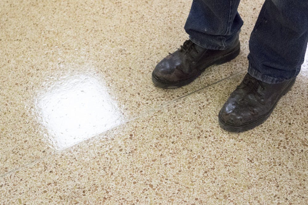 Custodian Greg Hobson stands in the entry way of one of the halls at the LaFollette Complex. Earlier in the break Hobson had stripped and re-waxed the floors, a task which he takes pride in. DN PHOTO JORDAN HUFFER