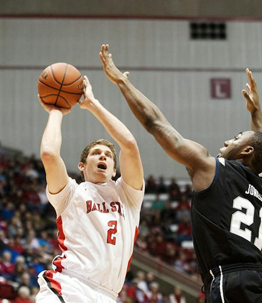 Sophomore Matt Kamieniecki attempts a jump shot over a Butler player. DN PHOTO BOBBY ELLIS