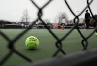 A stray ball sits on the court during a match March 26, 2021, in the Cardinal Creek Tennis Center. The Cardinals won 4-3 against the Falcons. Rylan Capper, DN 
