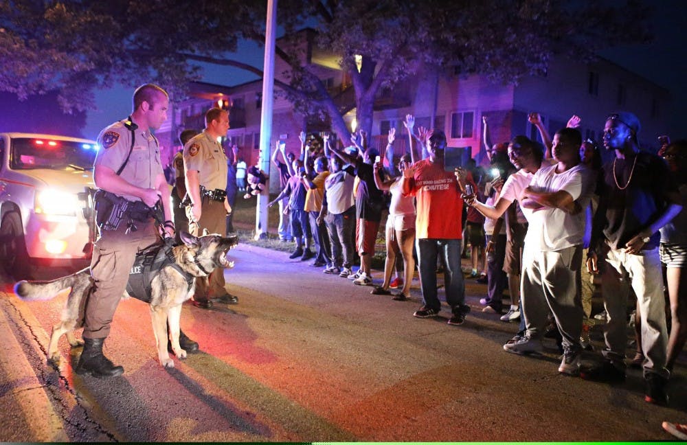 Police officers stand to confront a crowd they're trying to break up a demonstration in Ferguson, Mo., on Saturday, Aug. 9, 2014. Earlier in the day police had shot and killed an 18-year-old man. (David Carson/St. Louis Post-Dispatch/MCT)