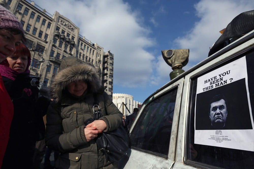 The interim government of Ukraine put its deposed President Viktor Yanukovych on a wanted list Monday. Women in Khreschatyk street in Kiev, Ukraine, look at an image of Yanukovych. MCT PHOTO
