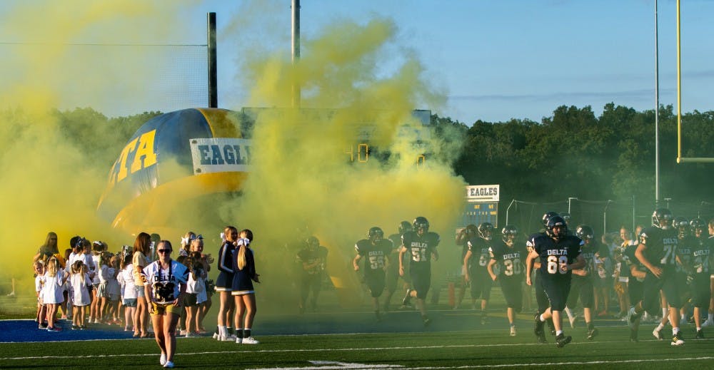 <p>The Delta Eagles run onto the field before their home opener against the Muncie Central Bearcats Aug. 23. Delta head coach Chris Overholt led the team to its first shutout during his time on staff. <strong>Jacob Musselman, DN</strong></p>