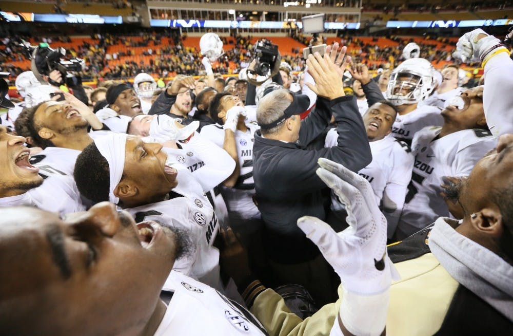 Missouri players crowd around head coach Gary Pinkel and chant his name after a 20-16 win against Brigham Young on Saturday, Nov. 14, 2015, at Arrowhead Stadium in Kansas City, Mo. (Chris Lee/St. Louis Post-Dispatch/TNS)