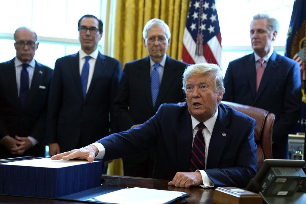 <p>President Donald Trump speaks before he signs the coronavirus stimulus relief package in the Oval Office at the White House, Friday, March 27, 2020, in Washington. Listening are from left, Larry Kudlow, White House chief economic adviser, Treasury Secretary Steven Mnuchin, Senate Majority Leader Mitch McConnell, R-Ky., and House Minority Leader Kevin McCarty of Calif. <strong>(AP Photo/Evan Vucci)</strong></p>