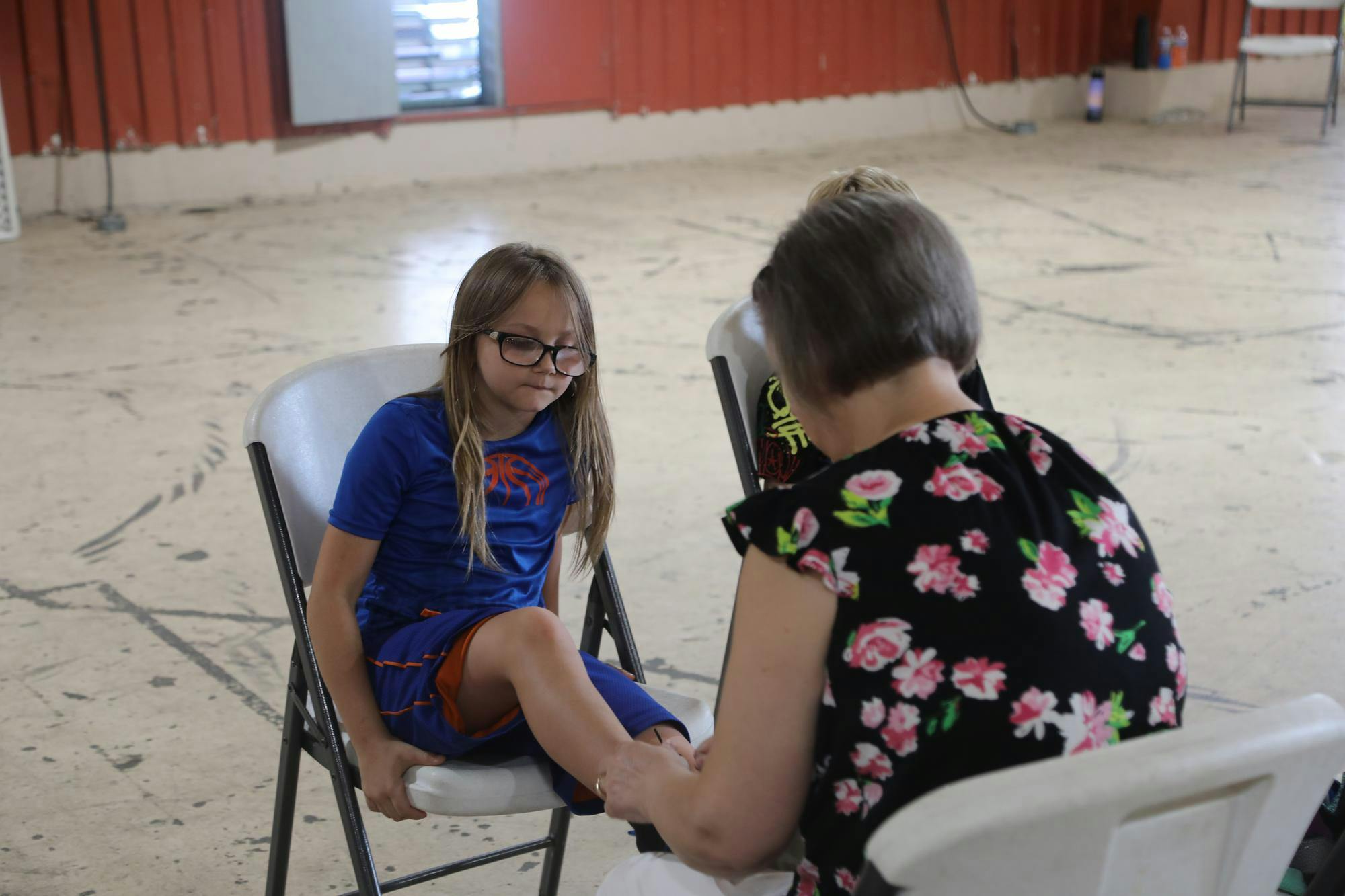 A volunteer helps a child pick out and try on shoes for the upcoming school year at the Delaware County Fairgrounds. Over 1500 children were helped at the Tools for School event. Elijah Poe, DN