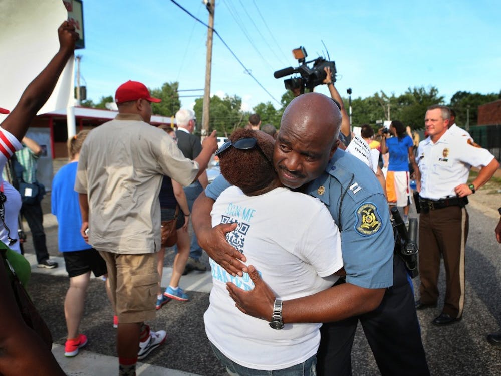 Missouri State Highway Patrol Capt. Ron Johnson gets a hug from Angela Whitman as a crowd of protesters march down Canfield Drive on Thursday, Aug. 14, 2014 in Ferguson, Mo. (David Carson/St. Louis Post-Dispatch/MCT)