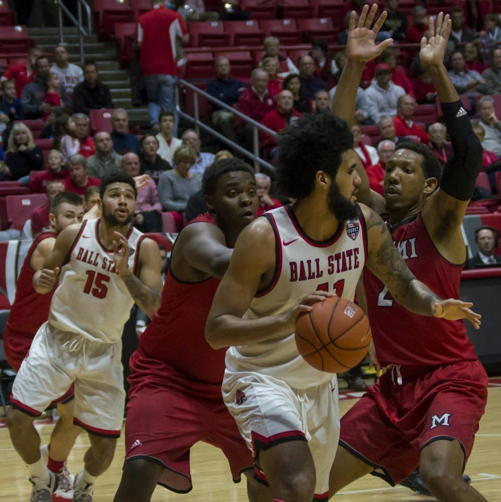 <p>Ball State center Trey Moses attempts to pass the ball during the game against Miami on Jan. 10 in Worthen Arena. The men's basketball team won 85-74. Teri Lightning Jr., DN</p>