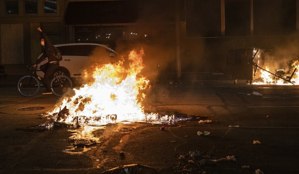 As night falls, protestors rally in downtown Indianapolis on Saturday, May 30, 2020. Protests were held in U.S. cities over the death of George Floyd, a black man who died after being restrained by Minneapolis police officers on May 25. (Mykal McEldowney/The Indianapolis Star via AP)