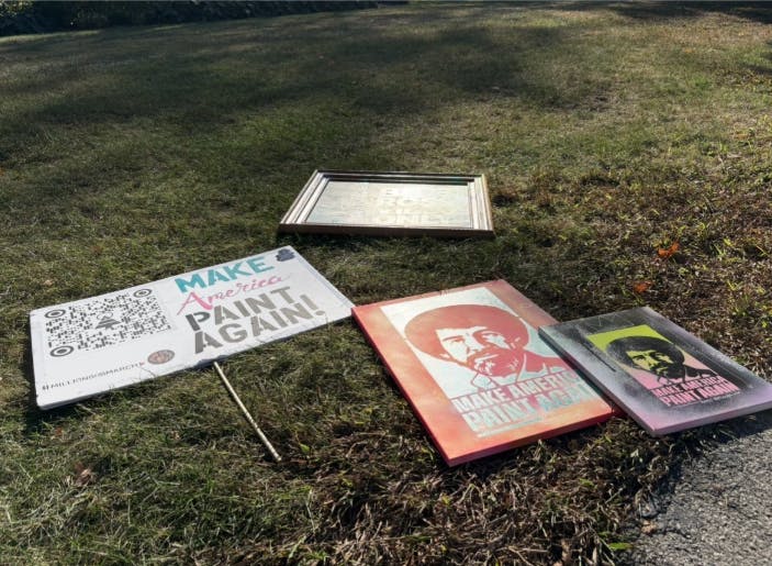 Several protest signs made by the organizer lay outside the Beneficence monument on Ball State University campus.