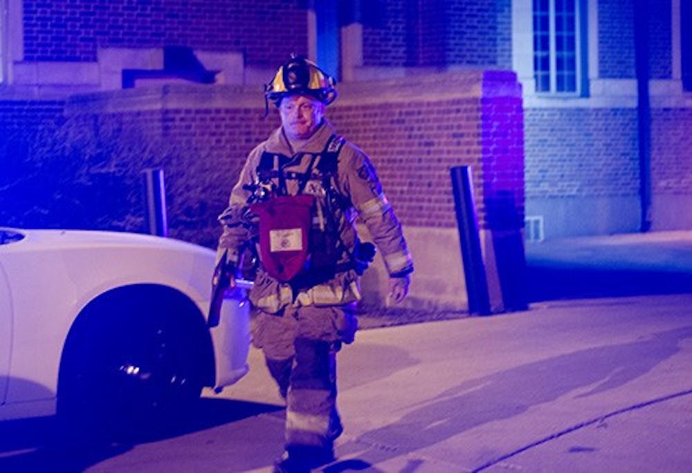 A Muncie firefighter leaves the Fine Arts Building and Museum of Art. A series false alarms around the Quad April 10 caused the department to respond to the area twice. DN PHOTO COREY OHLENKAMP