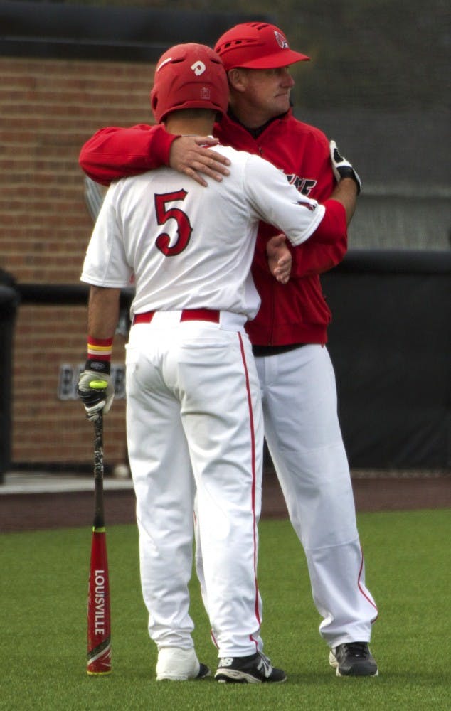 Ball State’s head baseball coach Rich Maloney gives senior infielder Ryan Spaulding a hug while the players from Ohio take a time out in the game on April 1. DN PHOTO GRACE RAMEY