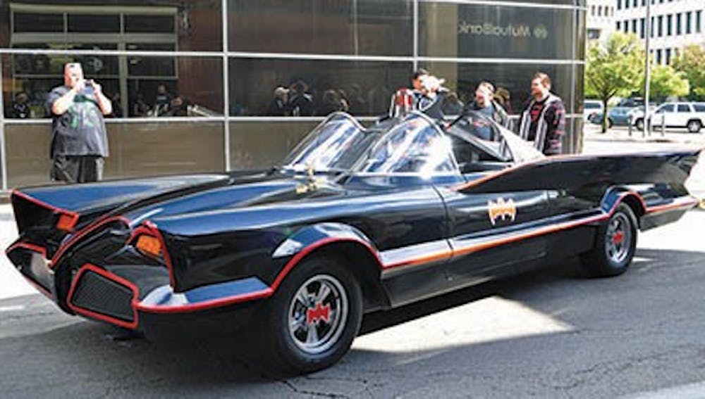 Several comic book fans take photos of the 1966 version of the Batmobile was parked outside of Alter Ego Comics during its grand reopening on Sept. 21. Mark Racop and a 15-person team replicate the 1966 Batmobiles. DN FILE PHOTO REBEKAH FLOYD