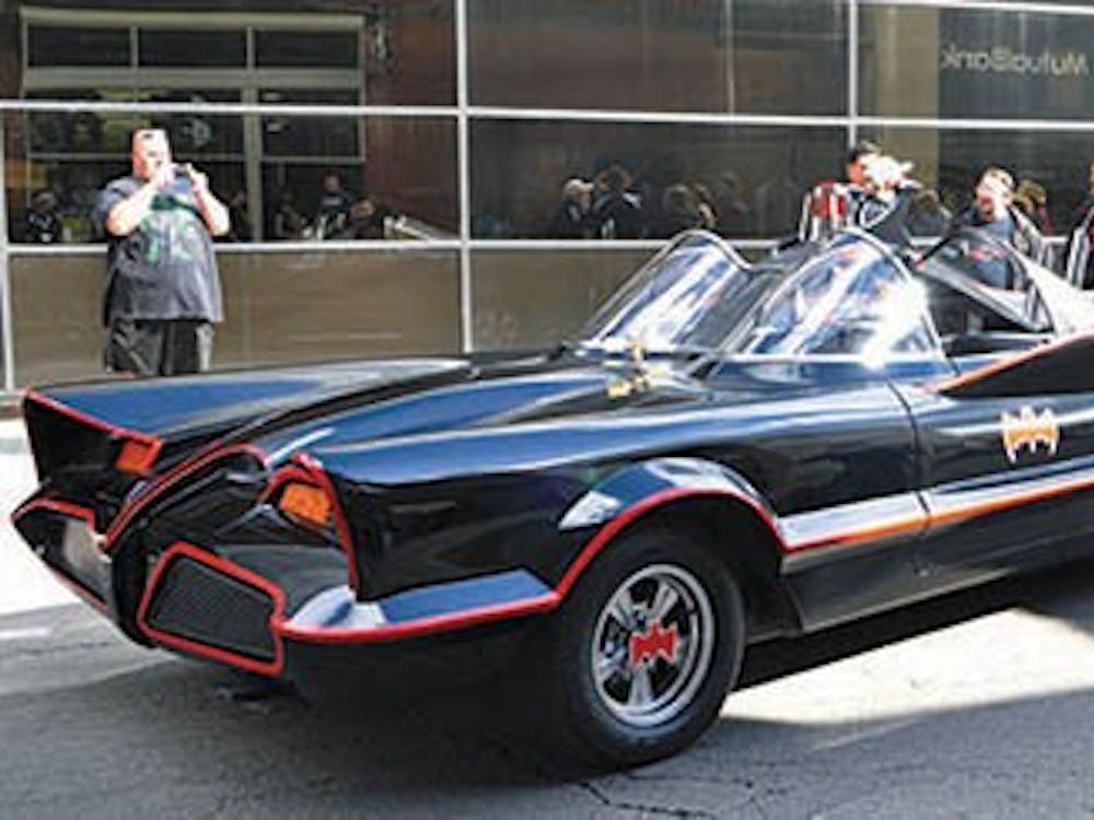 Several comic book fans take photos of the 1966 version of the Batmobile was parked outside of Alter Ego Comics during its grand reopening on Sept. 21. Mark Racop and a 15-person team replicate the 1966 Batmobiles. DN FILE PHOTO REBEKAH FLOYD