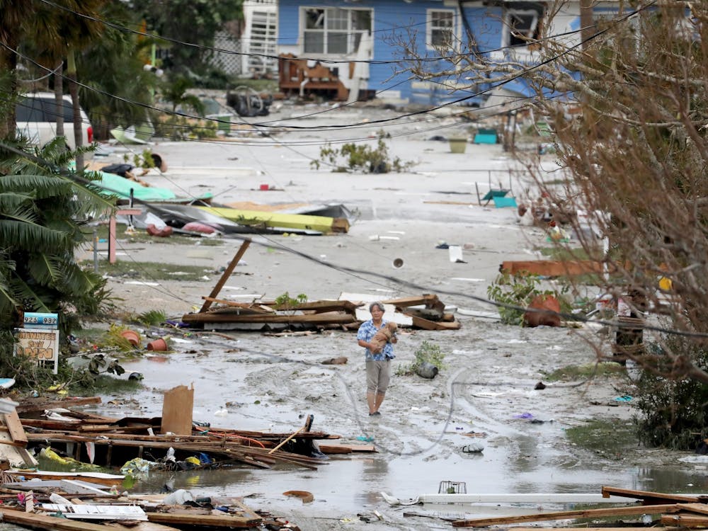 Pat Ton, holding his dog Ginger, takes in the damage to homes and businesses on 3rd Street at Fort Myers Beach on Thursday, Sep. 29, 2022, which was mostly destroyed after Hurricane Ian made landfall overnight on Wednesday. (Douglas R. Clifford/Tamps Bay Times/TNS)