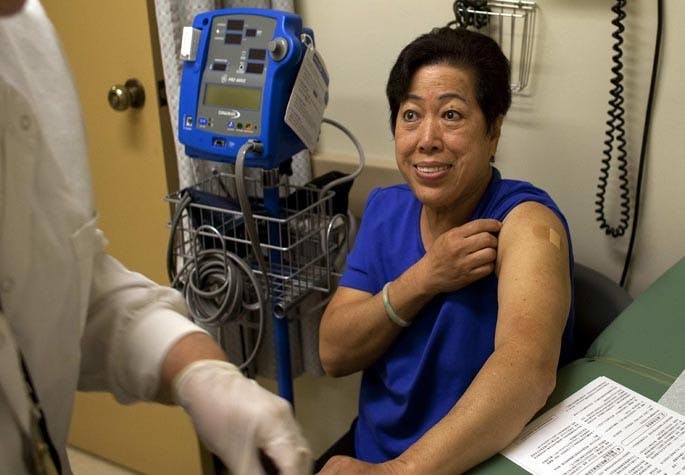 Healthy Ways L.A. patient Kien Hue Hua rolls down her sleeve after getting a flu shot at the El Monte Comprehensive Health Center in El Monte, California. Healthy Ways L.A. is a no-cost health coverage for uninsured Los Angeles county residents between the ages of 19 and 64. (Gina Ferazzi/Los Angeles Times/MCT)