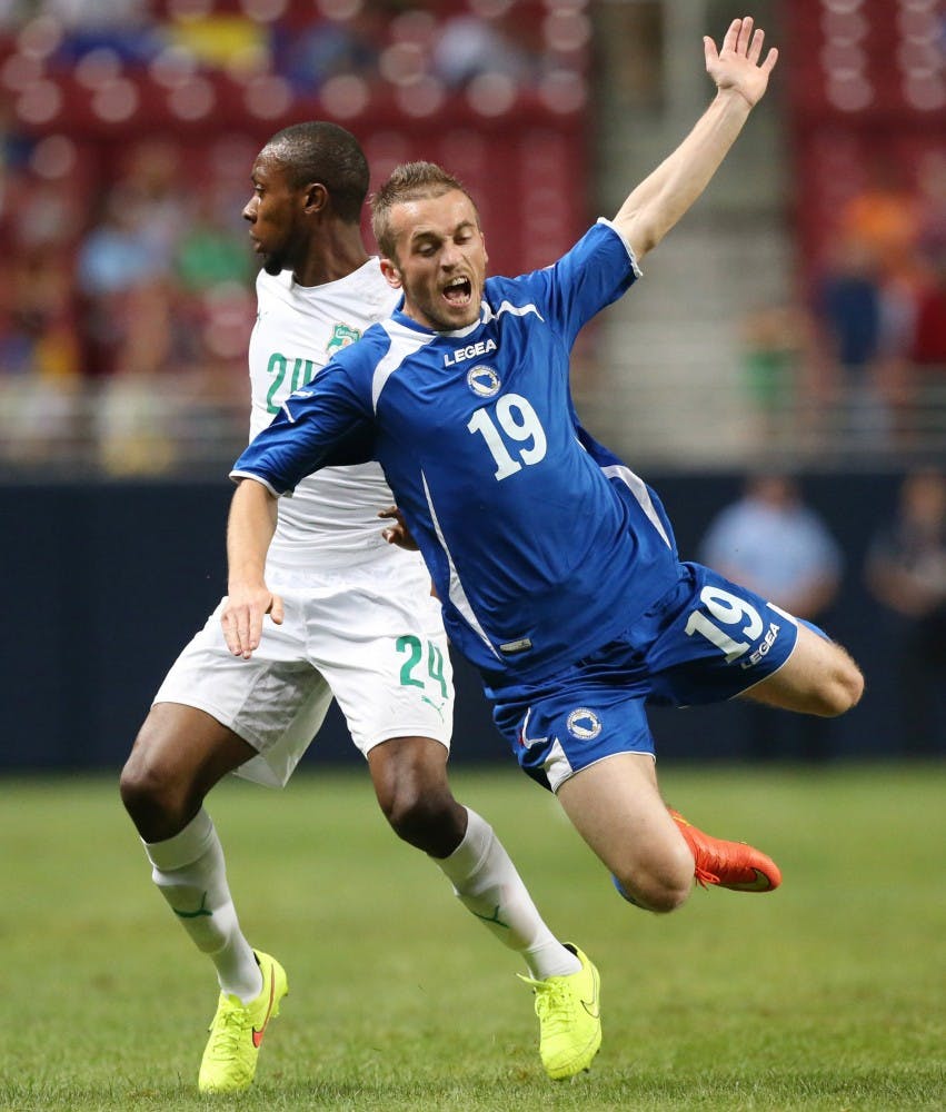 Bosnia forward Edin Visca (19) is sent airborne by Ivory Coast defenseman Jean-Daniel Akpa Akpro in first-half action in an international friendly on Friday, May 30, 2014, at the Edward Jones Dome in St. Louis. (Chris Lee/St. Louis Post-Dispatch/MCT)