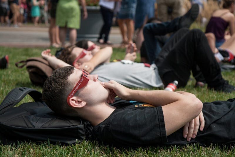 Students and community members gather on the University Green on Aug. 21 for the Eclipse Viewing Party. 93 percent of the sun was covered by the moon by 2:25pm. Kaiti Sullivan // DN