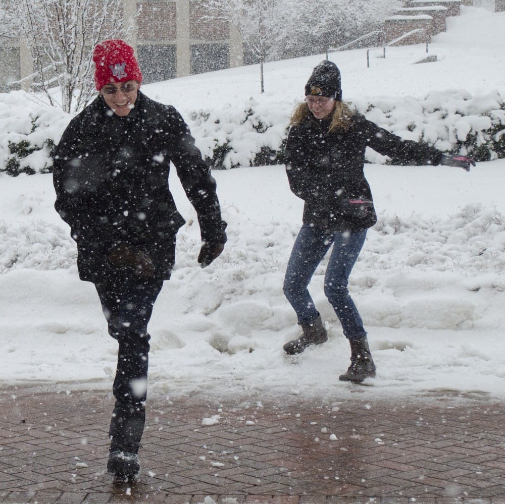 Junior interior design major Yasha Ogg runs from freshman art major Marisa Lozano during their snowball fight on Jan. 5 in front of Teachers College. DN PHOTO BREANNA DAUGHERTY