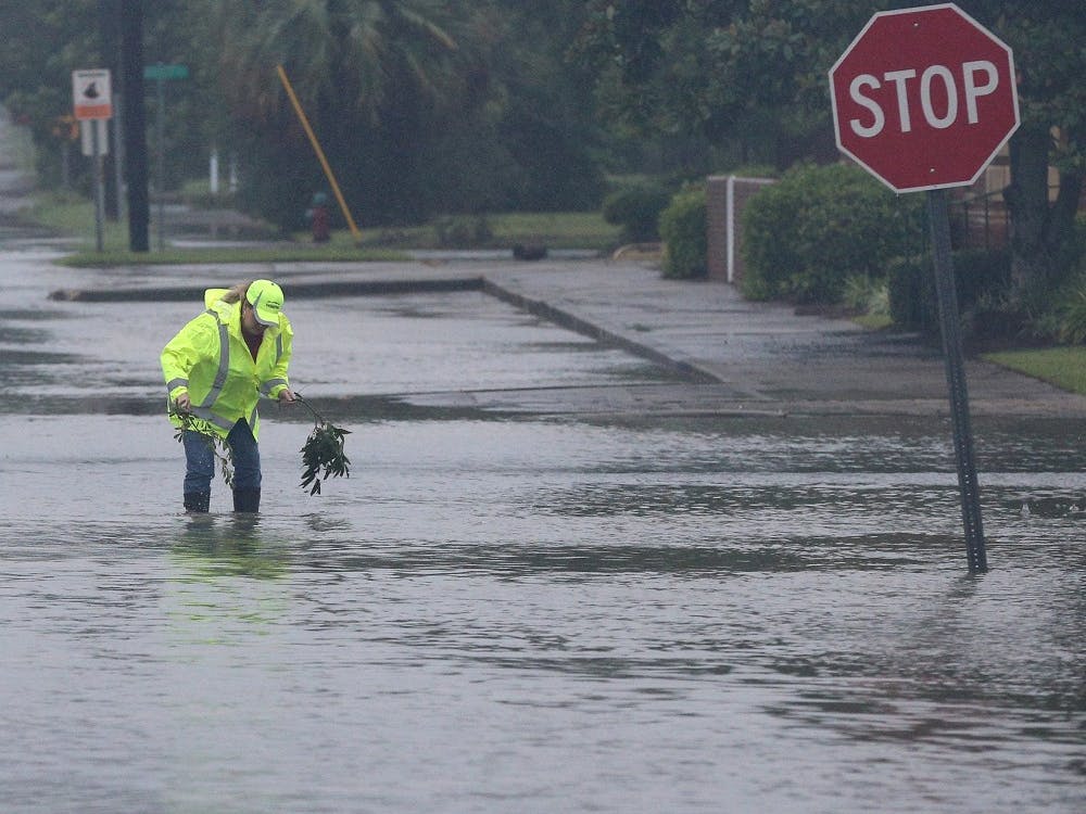 A city employee works to clear storm drains on flooded Isabella Street in the downtown area as Hurricane Irma moves through the city on Sept. 11 in Waycross, Ga. TNS Photo