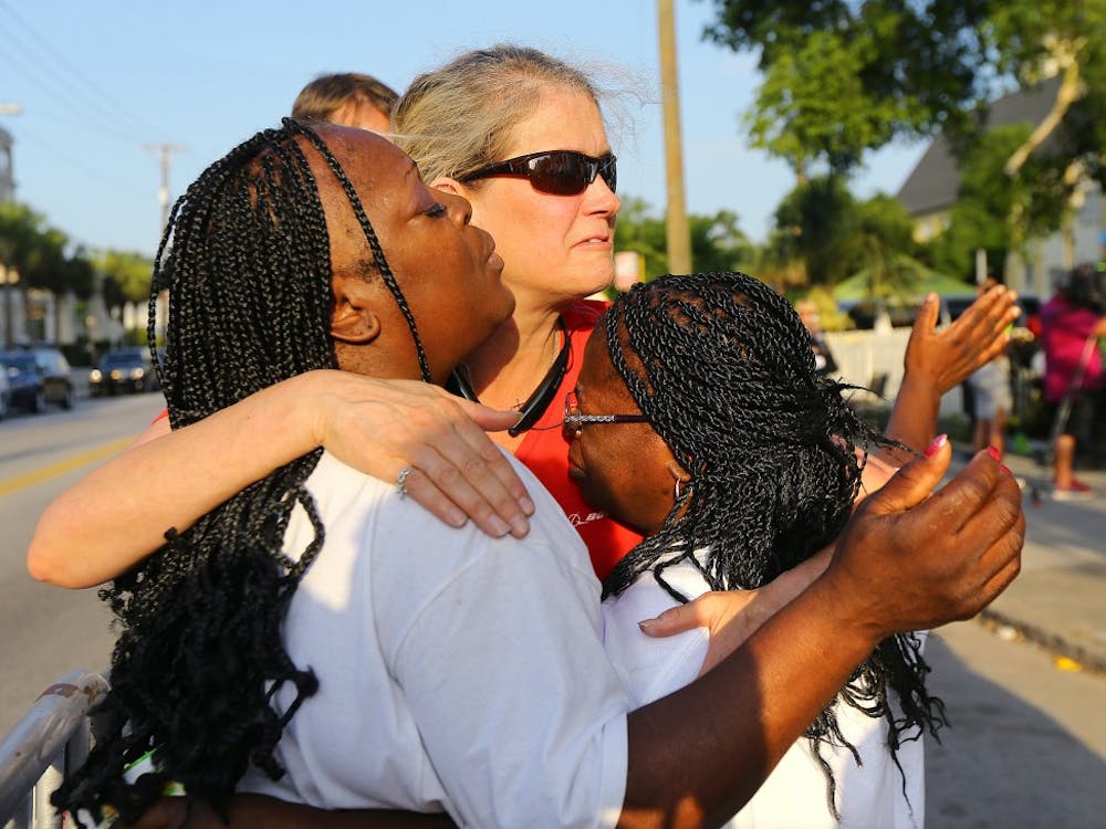 Crissa Jackson, from left, Cynthia Coates and Cynthia Jackson embrace one another and pray as they wait in line for the doors to reopen to the "Mother" Emanuel A.M.E. Church on Sunday, June 21, 2015, in Charleston, S.C. (Curtis Compton/Atlanta Journal-Constitution/TNS)