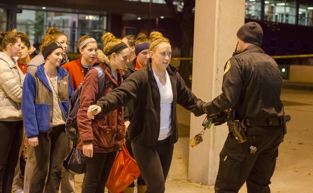 Police interview and search evacuees from the building as fellow officers secure the Student Recreation and Wellness Center, following a report of an armed assailant. DN PHOTO COREY OHLENKAMP
