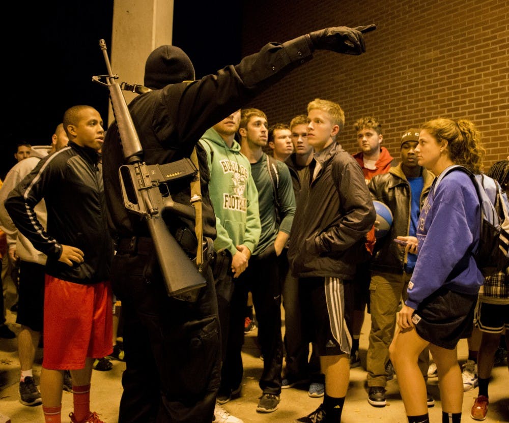  Officer R. Trissel tells students how they are allowed to leave after the report of an armed assailant Nov. 15 at the Student Recreation and Wellness Center. DN PHOTO TAYLOR IRBY