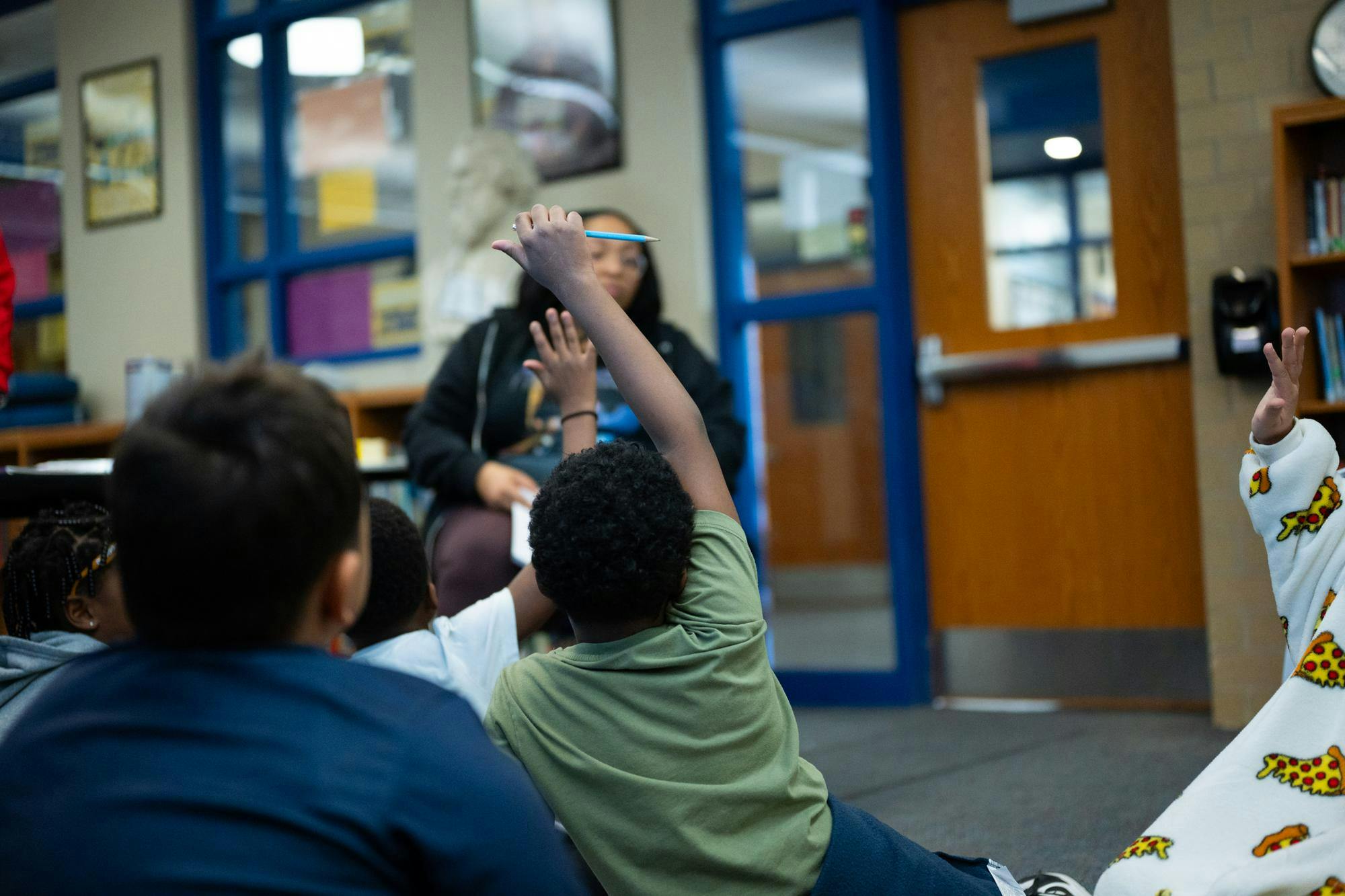 Students raise their hands to answer a question during "MP3", Longfellow Elementary's after-school program Jan. 23 at Longfellow Elementary. The program is coupled with a 3-week summer "Jumpstart" initiative that prepares students before the  fall semester starts.