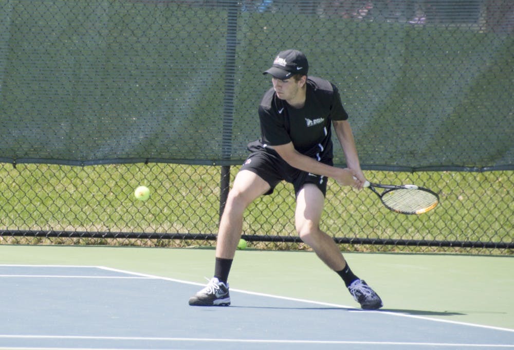 Sophomore Andrew Stutz hits the ball during the match against Western Michigan on April 11 at Cardinal Creek Tennis Courts. DN PHOTO ALAINA JAYE HALSEY