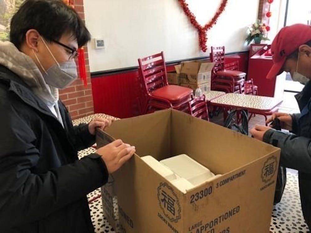 Senior journalism major Zi Wang packs boxes of to-go containers from Asian Kitchen Feb. 12, 2021. Due to COVID-19 restrictions, students couldn't gather in large groups to celebrate, so Wang individually distributed food to international students from China to celebrate Lunar New Year. Shiyi Sun, DN