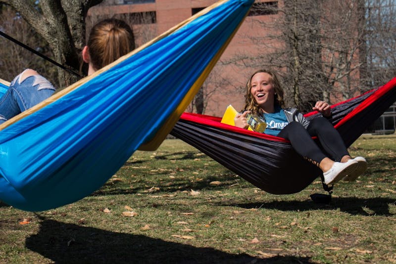 Ashley Miller and Lauren Hamil share a laugh after setting up their hammocks to enjoy the weather Feb. 27. Eric Pritchett, DN