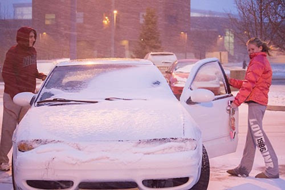 Students successfully open a car that had been locked by ice during the snowfall Sunday evening. The storm system that caused a winter storm advisory for all of central Indiana is expected to drop 4 to 10inches of snow, according the National Weather Service. DN PHOTO TAYLOR IRBY 