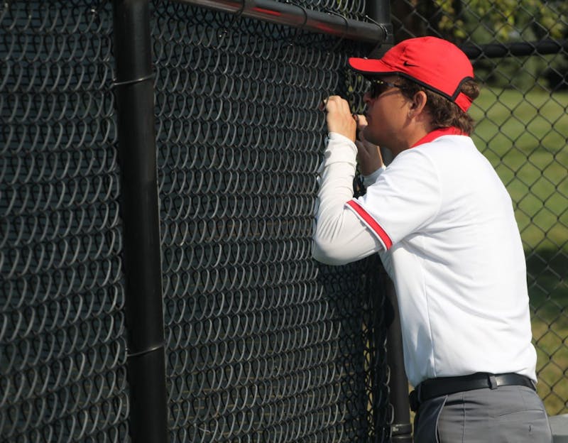 Women's tennis head coach Max Norris talks to senior Sarah Swiderski in her first round singles match against Detroit Mercy. Norris enters his sixth season as head coach of Ball State. Photo by Patrick Murphy