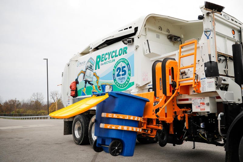 A sanitation truck uses its automated arm to grab and empty a blue recycling toter Nov. 13 at Muncie Sanitary District. The district recently introduced a new mascot based on its trucks, “Recyclor the Recyclon,” to promote proper recycling among children. Andrew Berger, DN 
