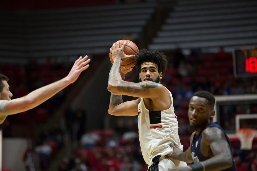 <p>Junior center Trey Moses looks to pass the ball during the game against Akron Jan. 27. Moses scored a career high of 20 points throughout the name.<strong> Eric Pritchett, DN</strong></p>
