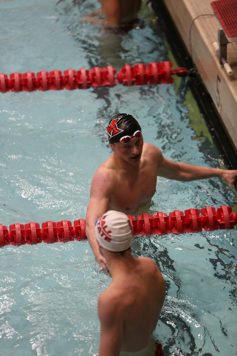 Miami's Owen Blazer shacks hands with Ball State's Ethan Peifer after swimming the 200 yard backstroke Oct. 28 in Lewellen Aquatic Center. Blazer won the event with a time of 1:55.89. Eli Houser, DN 